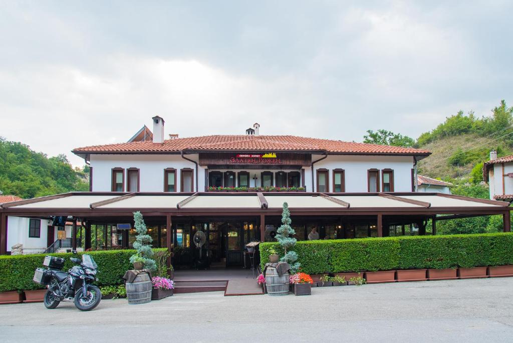RozhenにあるZlaten Rozhen Family Hotel- Monument of Cultural Significanceの正面にバイクが停まった建物