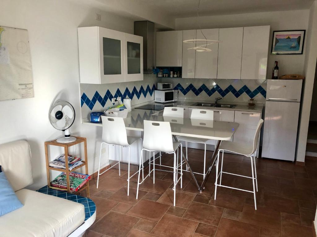 a kitchen with a table and chairs and a couch at Villa Perdalonga in Teulada