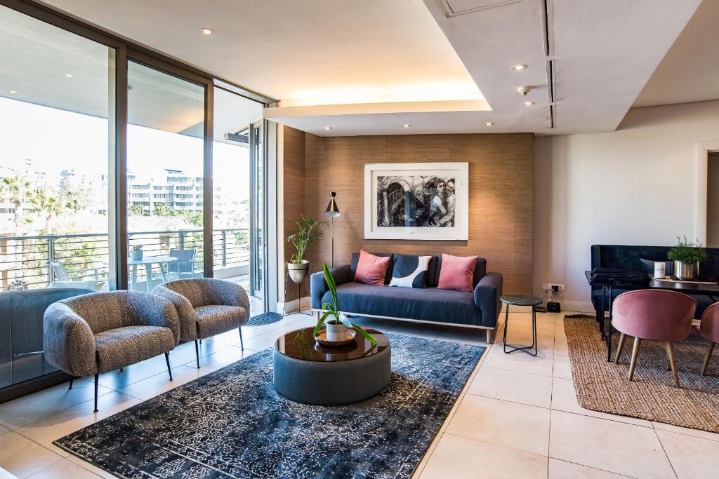 een woonkamer met een bank en een piano bij Elegant Waterfront Apartment with No Loadshedding in Kaapstad