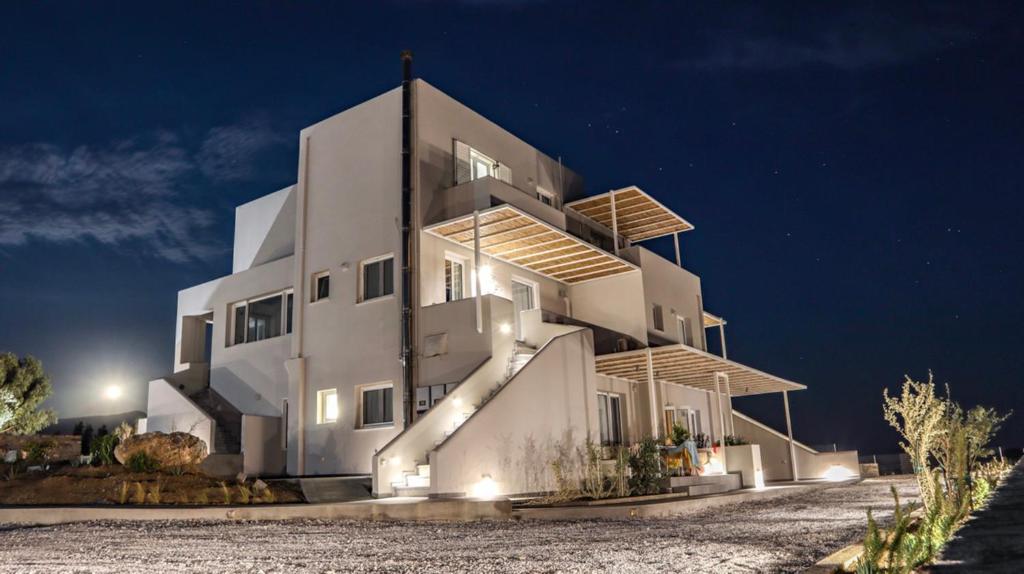 ein großes weißes Gebäude in der Nacht in der Unterkunft Pharos Apartments in Gavrio