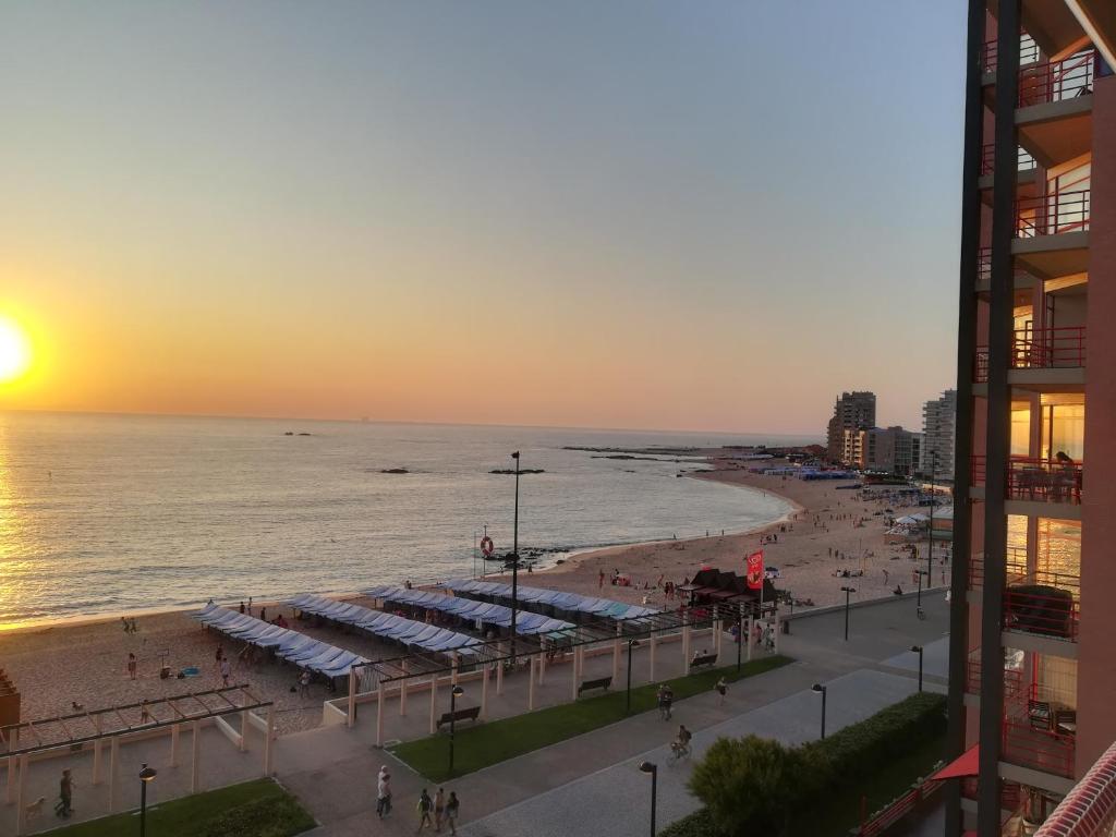 ポボア・デ・バルジンにあるApartamento na Praiaの海と夕日のビーチの景色