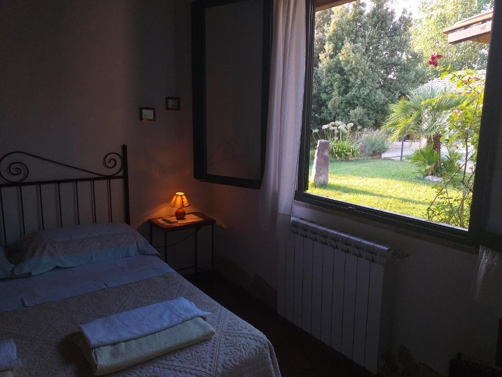 1 dormitorio con cama y ventana grande en B&B Is Camminantis, en Nurallào