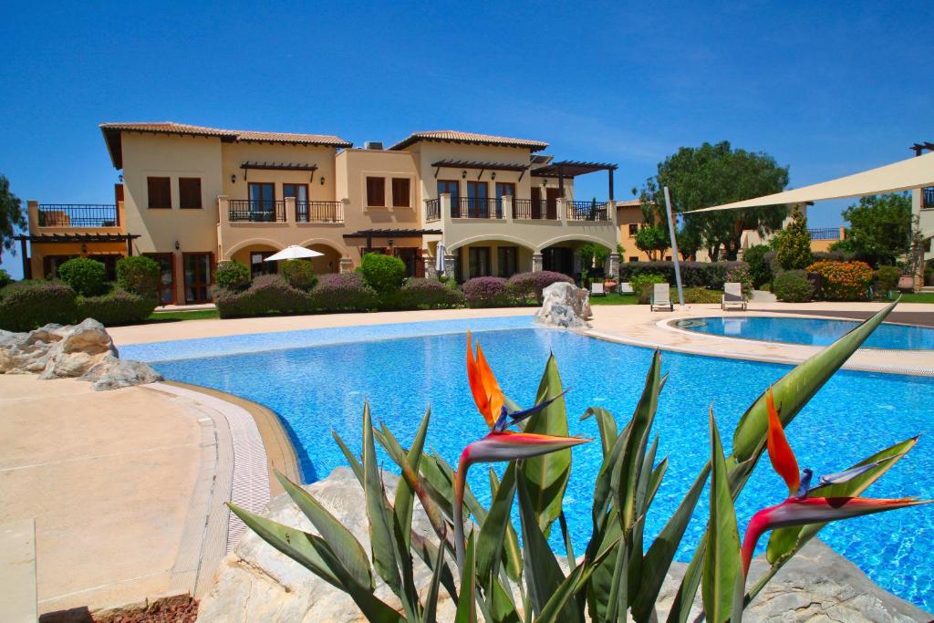 uma villa com uma piscina e uma casa em Aphrodite Hills Rentals - Apartments em Kouklia