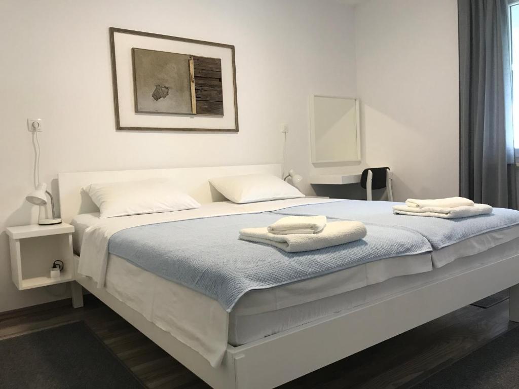 a white bed with two towels on top of it at Apartment Romeo in Crikvenica
