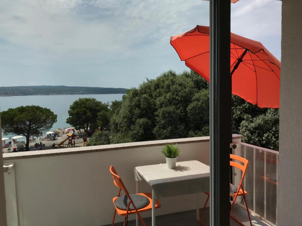 a table and chairs with an umbrella on a balcony at Apartment Romeo in Crikvenica