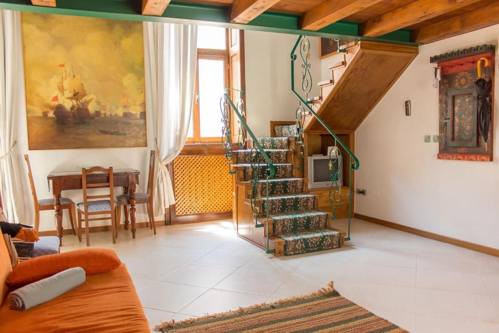een woonkamer met een wenteltrap en een tafel bij 5 Comfortable apartment near old town center in Timişoara