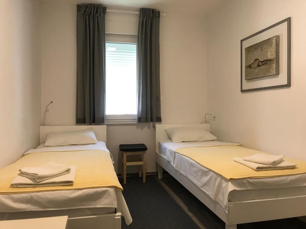two beds in a room with a window at Apartment Romeo in Crikvenica