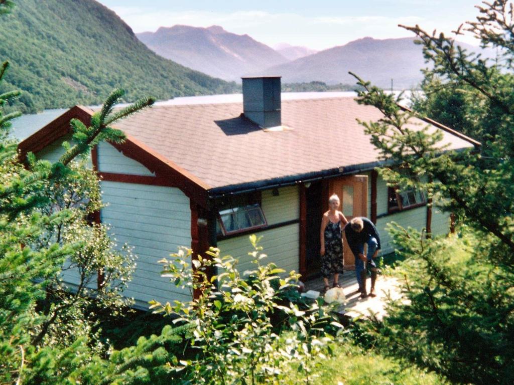 Ein paar Leute stehen vor einem Haus. in der Unterkunft Two-Bedroom Holiday home in Engavågen 1 in Åmnes