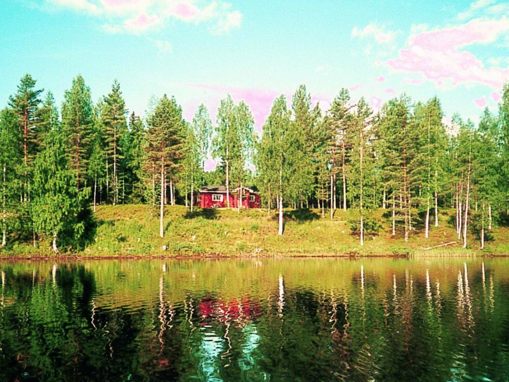 a red house on a hill next to a lake at 4 person holiday home in TORSBY in Mårbacken