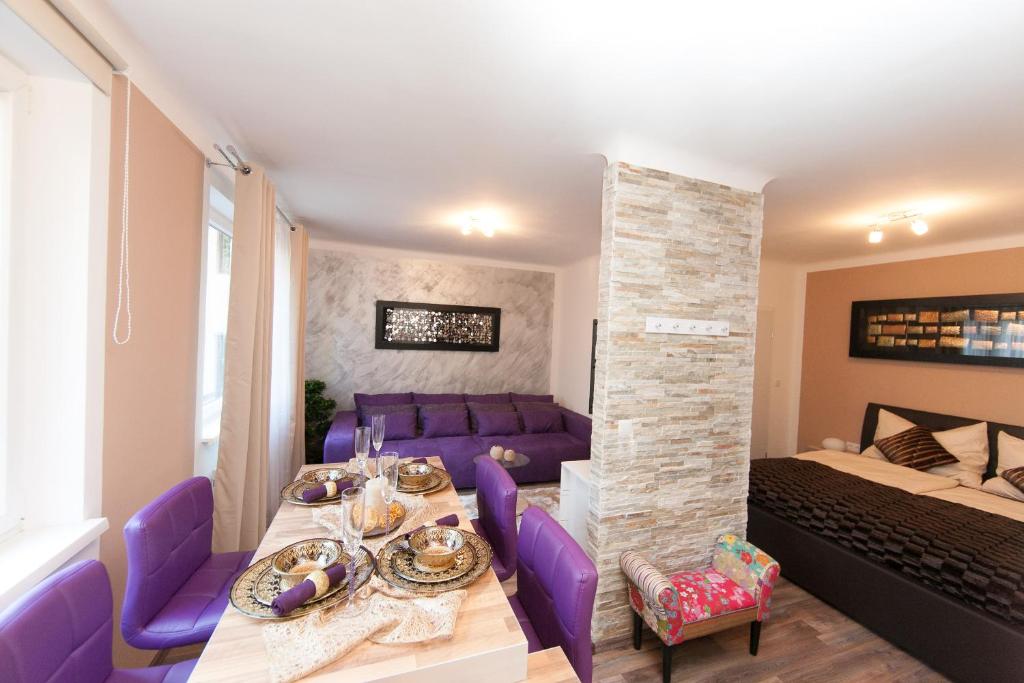 ein Esszimmer mit einem Tisch und lila Stühlen in der Unterkunft Traditional Apartments Vienna TAV - Design in Wien