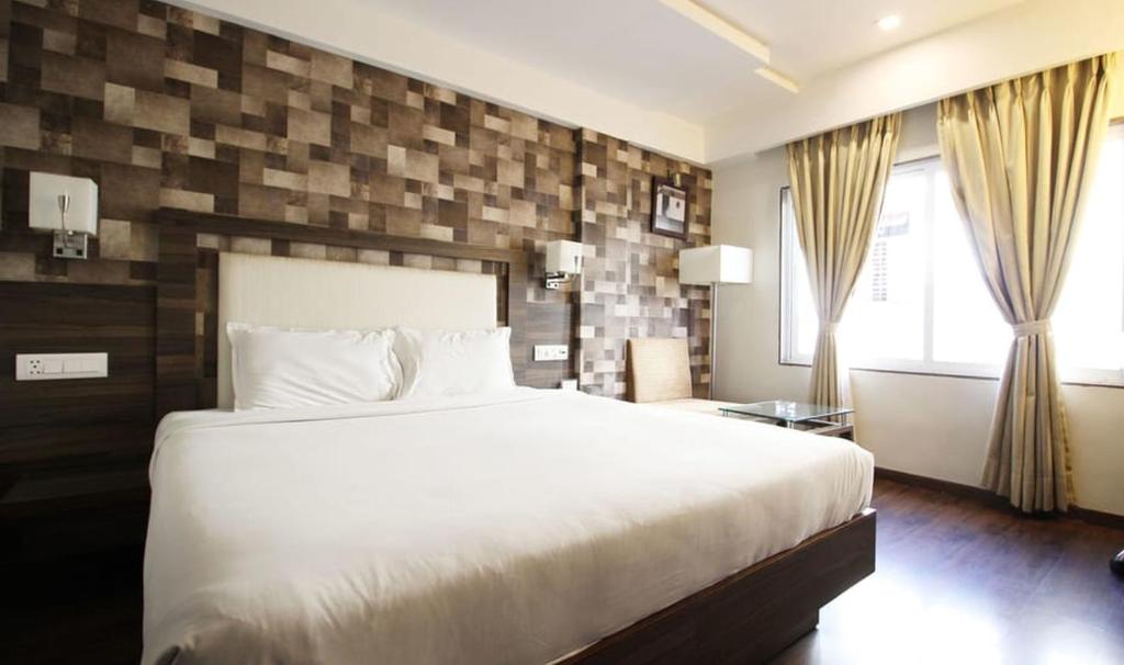 Postel nebo postele na pokoji v ubytování Hotel Aaram Orchard