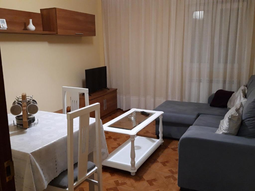 een woonkamer met een bank en een tafel bij PISO CERCA DEL SARDINERO in Santander