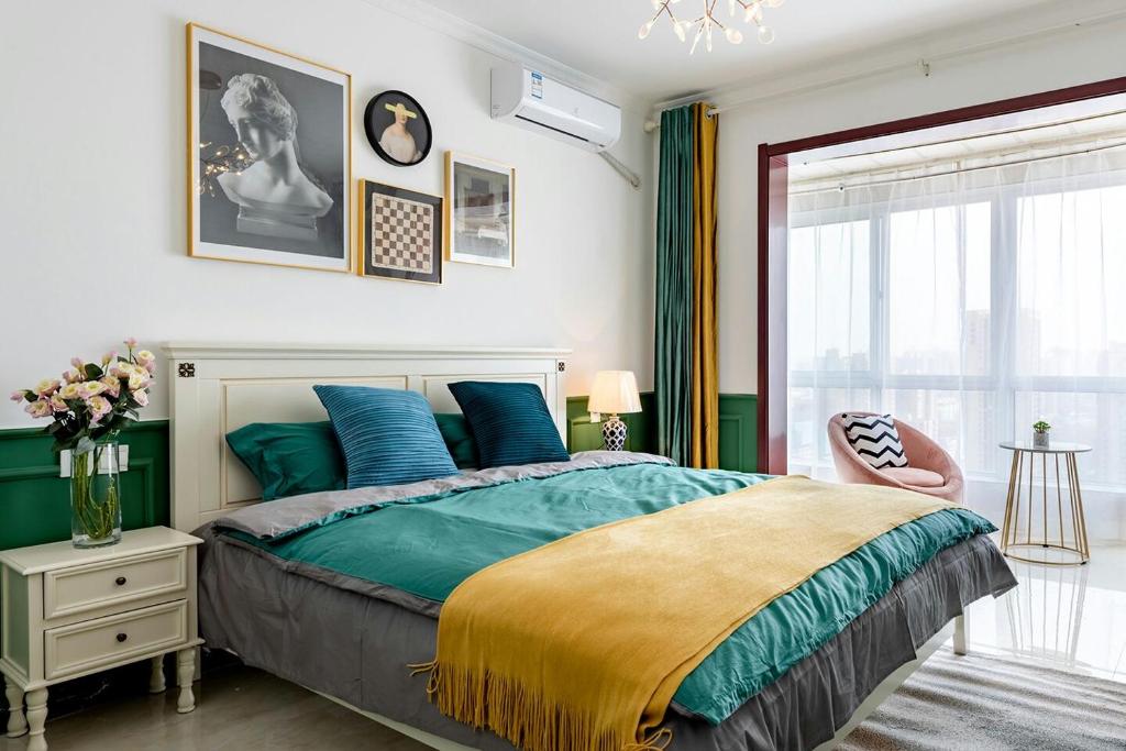 ein Schlafzimmer mit einem Bett in Blau und Grün in der Unterkunft Xi 'an lianhu district · kaiyuanmen · Luke boutique apartment ·00184770 in Xi'an