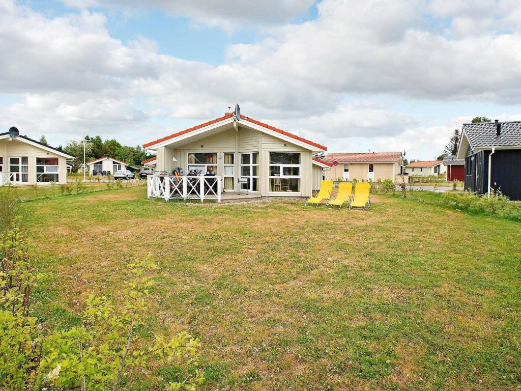 a house with yellow chairs in a yard at Three-Bedroom Holiday home in Grömitz 20 in Grömitz