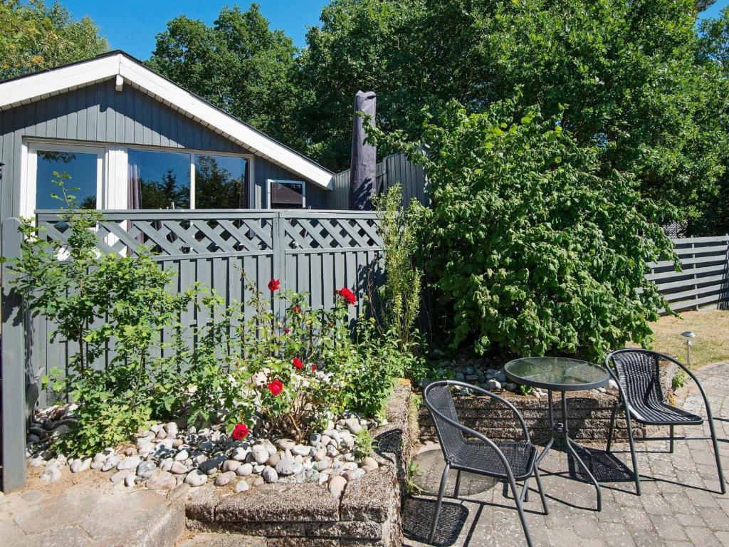 una valla con mesa y sillas en un jardín en 4 person holiday home in R nde, en Dagstrup