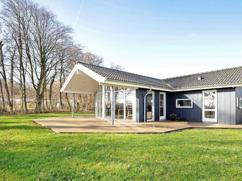 una casa azul con porche y patio en 8 person holiday home in Sj lund, en Hejls