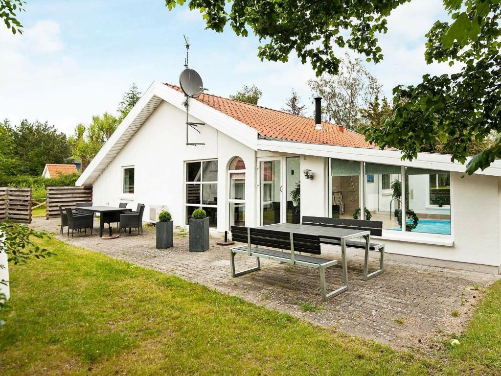 エーベルトフトにある8 person holiday home in Ebeltoftの白い家(ピクニックテーブル、ベンチ付)