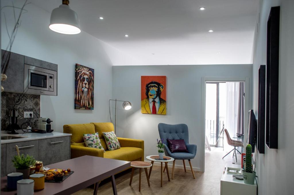 sala de estar con sofá amarillo y mesa en Apartamentos Turísticos Moret11-1A, en Cáceres