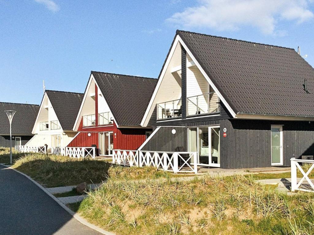 eine Reihe von Häusern in Rot und Weiß in der Unterkunft Two-Bedroom Holiday home in Wendtorf 17 in Wendtorf