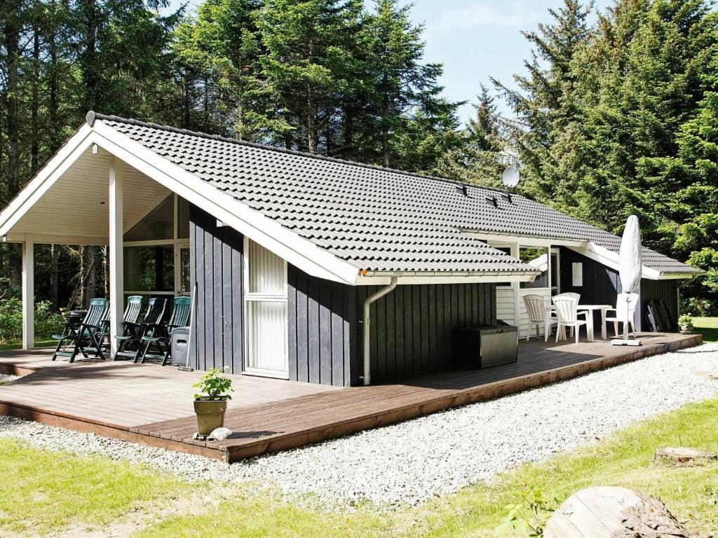 Casa pequeña con terraza de madera en el patio en 8 person holiday home in L kken, en Lønstrup