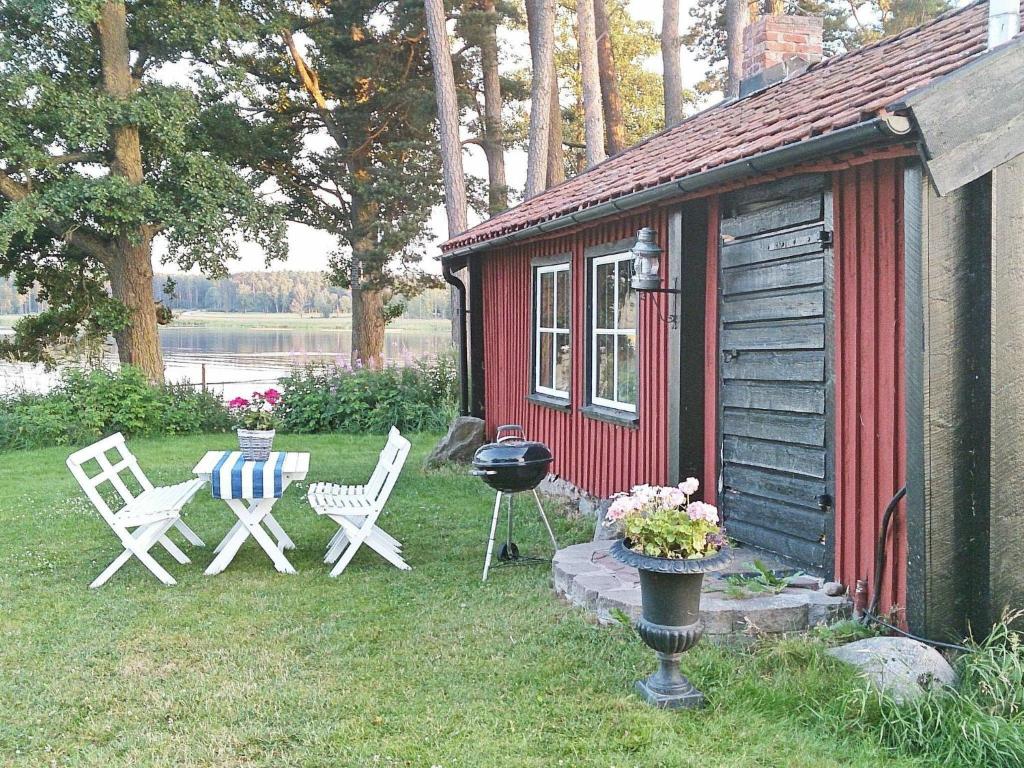 una cabina roja con sillas y una parrilla en el patio en 4 person holiday home in HOVA, en Hova