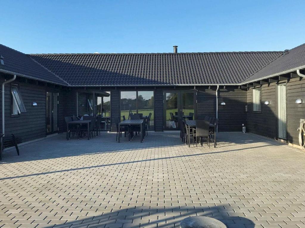 a patio with tables and chairs in a building at 24 person holiday home in Stege in Stege