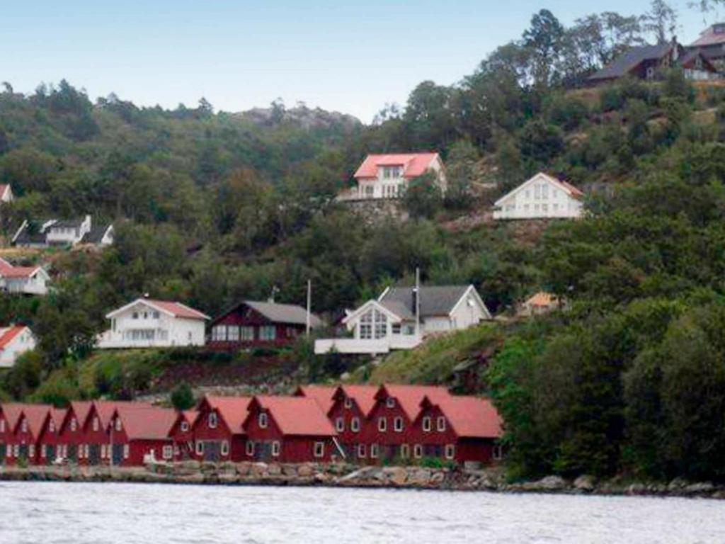 un grupo de casas en una colina junto al agua en 10 person holiday home in Lindesnes, en Spangereid