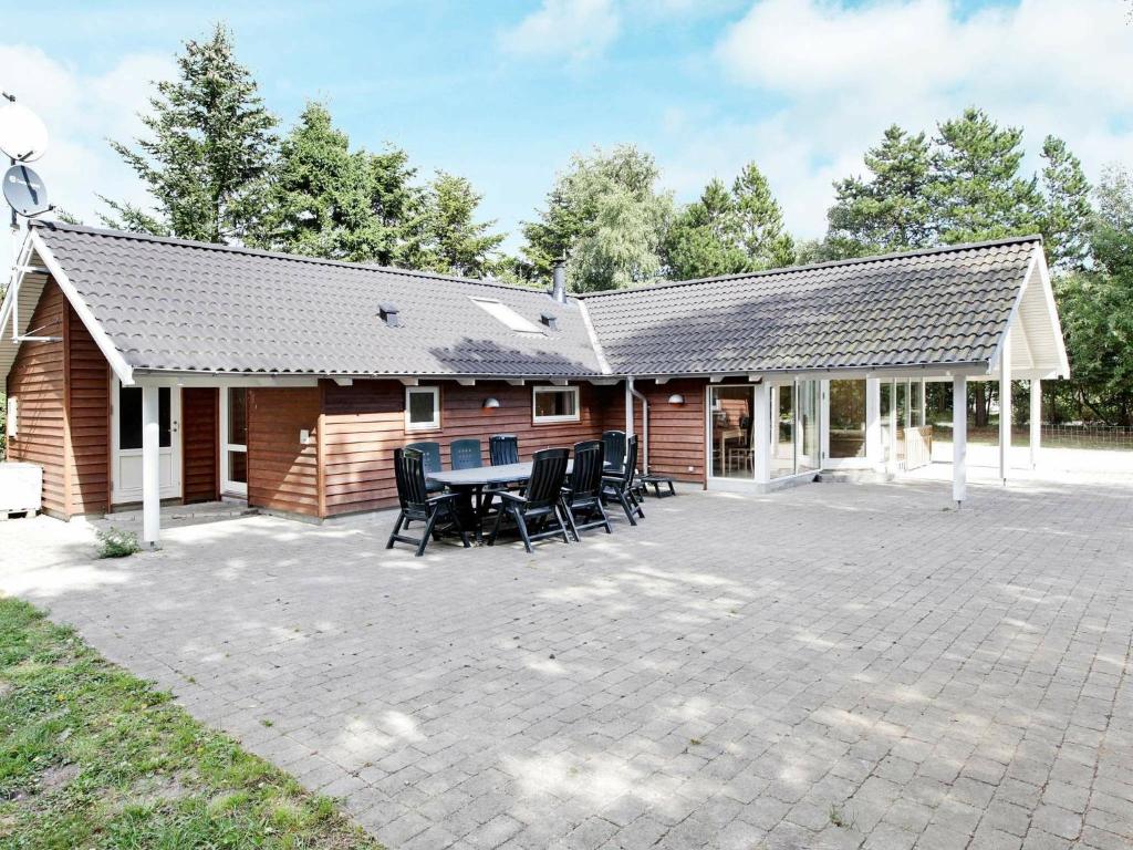 a cabin with a table and chairs on a patio at 12 person holiday home in R dby in Kramnitse