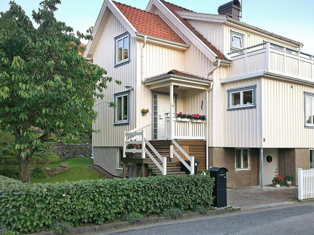 uma grande casa branca com um alpendre e escadas em 4 person holiday home in Sk rhamn em Skärhamn