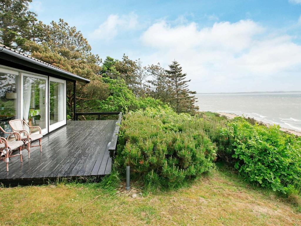 a house with a deck with a view of the ocean at Holiday Home Sitkagranvej in Lihme