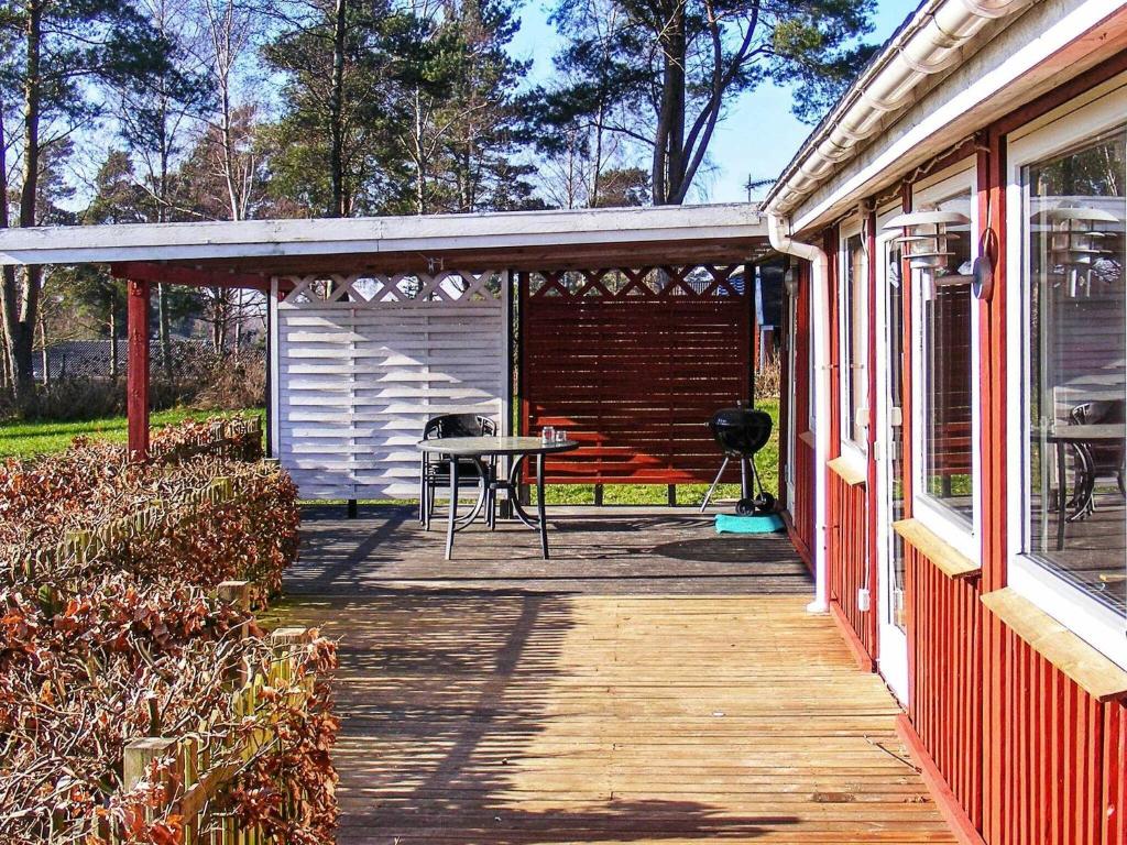 a covered porch of a house with a table at Two-Bedroom Holiday home in Vordingborg 2 in Vordingborg