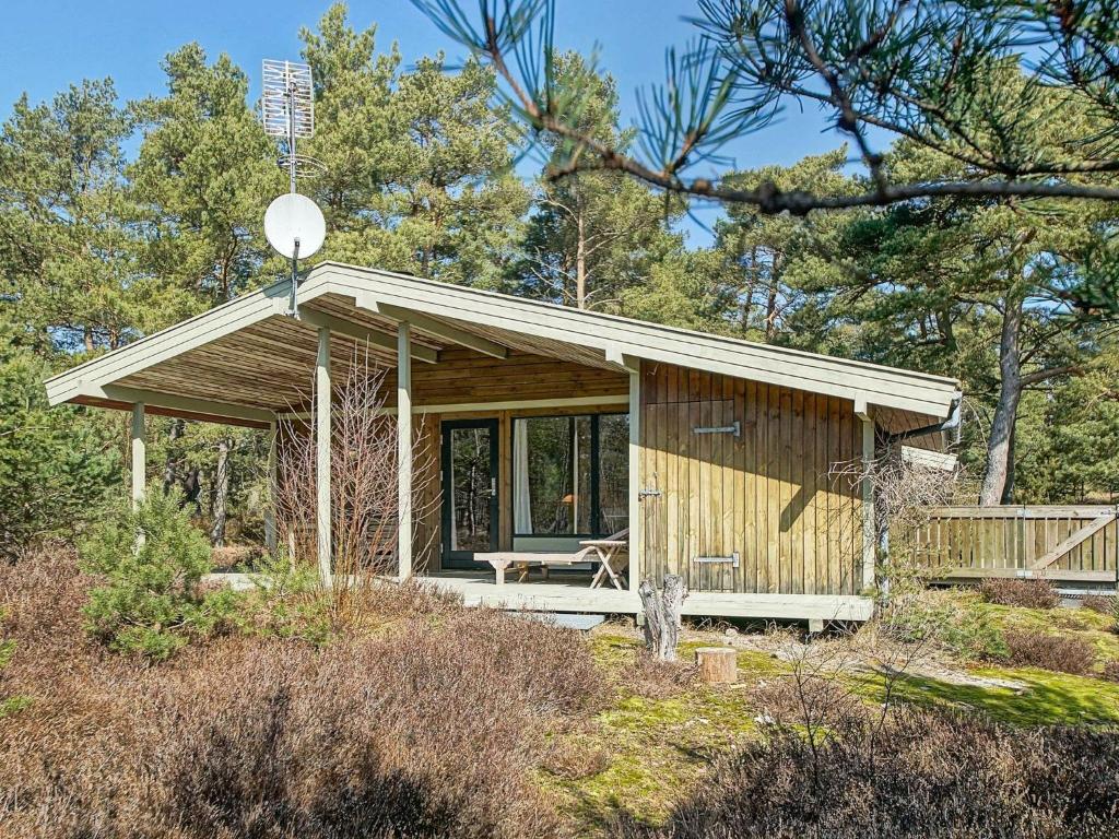 mały domek z werandą w lesie w obiekcie 6 person holiday home in Nex w mieście Vester Sømarken