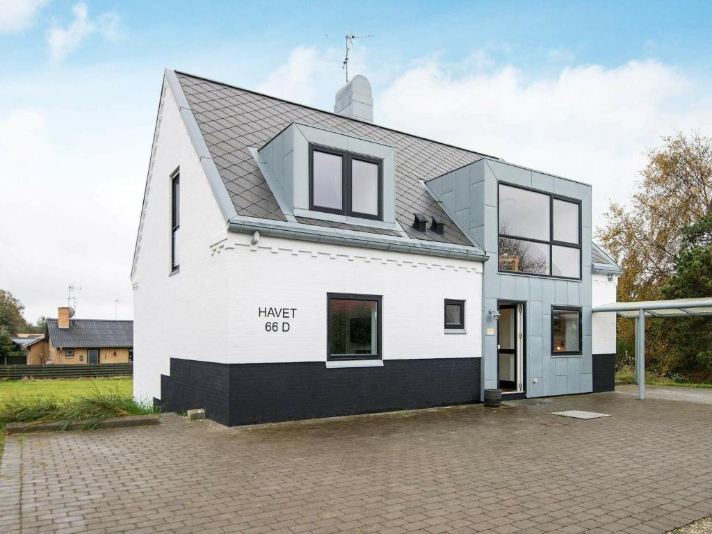 ein weißes Haus mit schwarzem Dach in der Unterkunft 10 person holiday home in Glesborg in Bønnerup