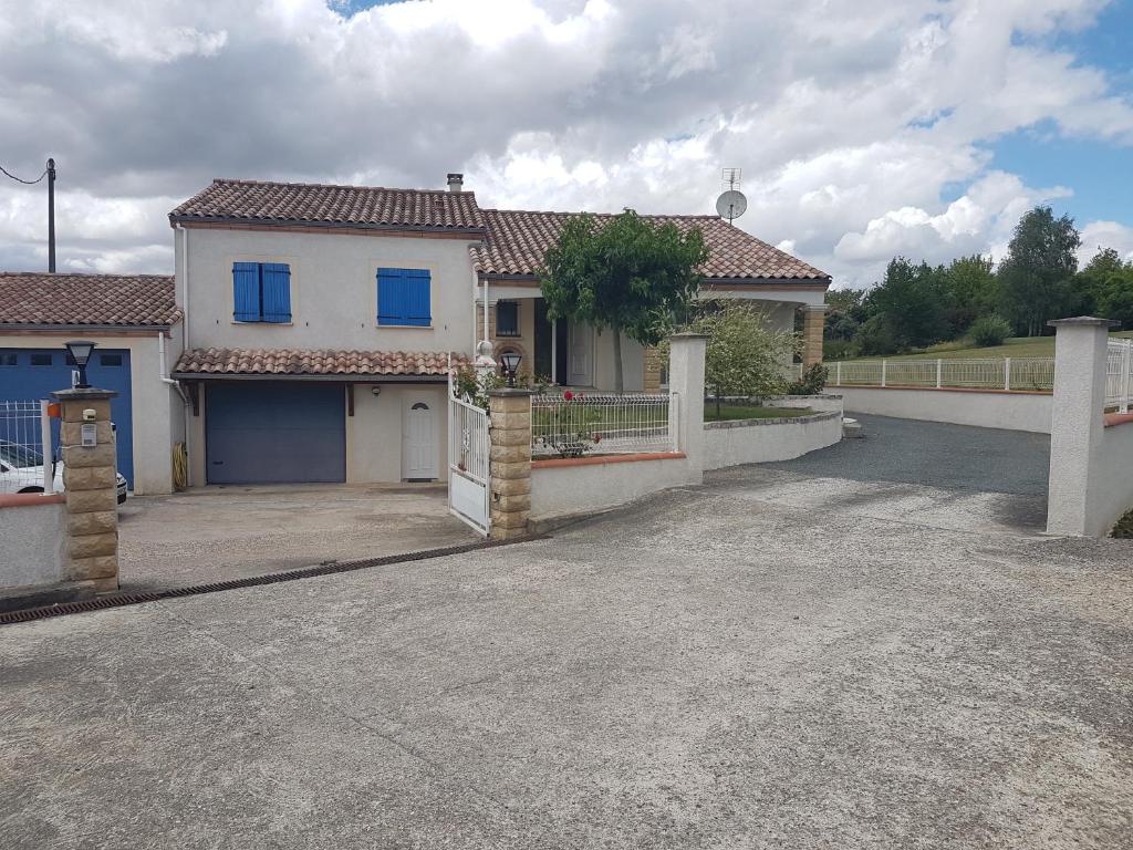 uma casa branca com uma cerca e uma entrada em T1 Dans Maison Au Calme em Réalmont