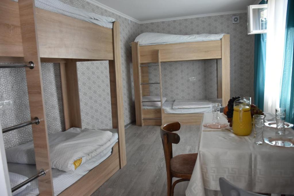 Habitación pequeña con 2 literas y mesa. en Babulya House en Gyumri