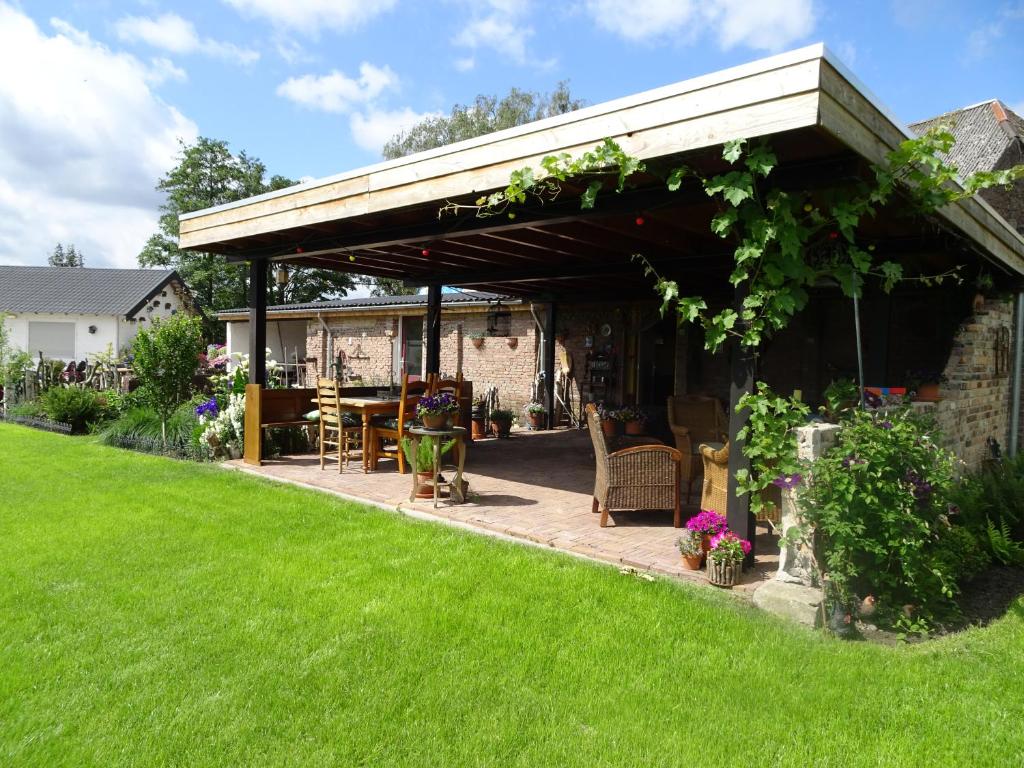 eine Pergola mit einem Tisch und Stühlen im Hof in der Unterkunft Casa Tranquila in Ooij