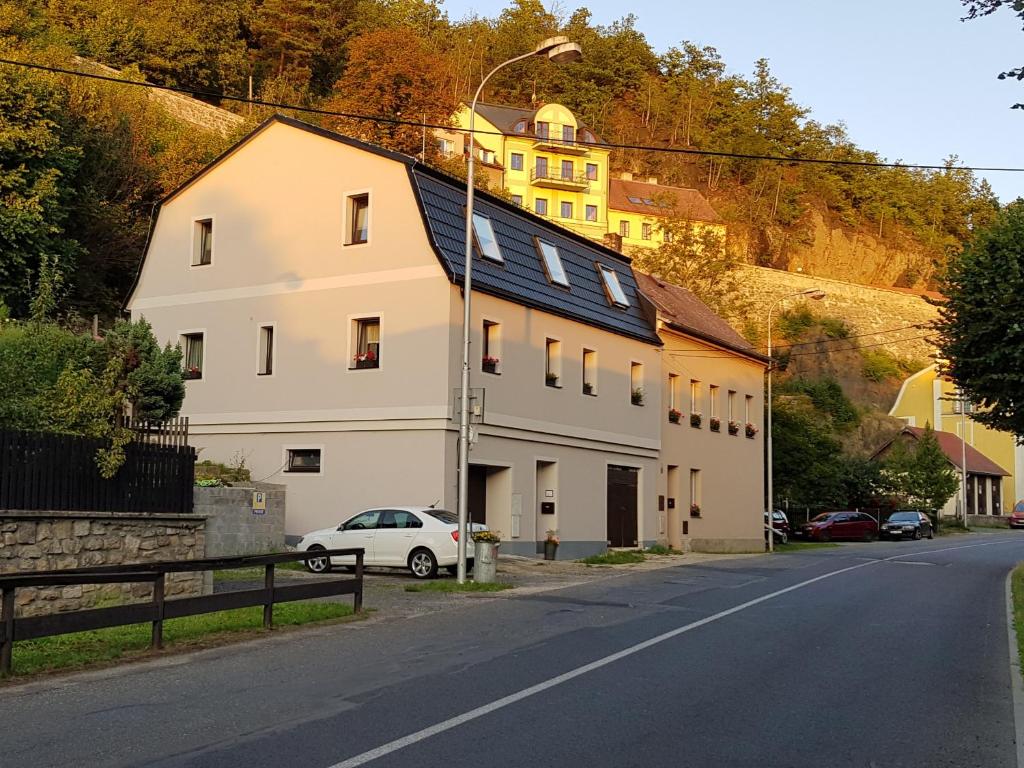 uma casa branca ao lado de uma rua em Apartmány u Kuželky em Loket