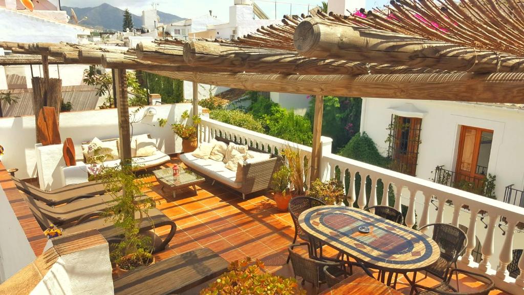 een patio met een tafel en stoelen op een balkon bij Casa Jazmin Carabeo in Nerja