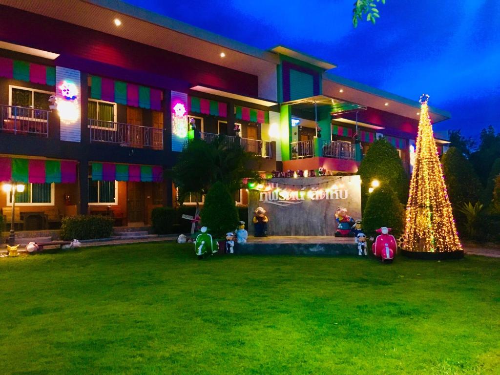 een groot gebouw met een kerstboom ervoor bij บ้านทิพรัตน์ สัตหีบ in Sattahip