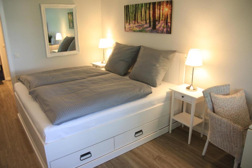een bed in een kamer met een spiegel en een stoel bij Seaside Appartement 458 Vier Jahreszeiten in Hahnenklee-Bockswiese