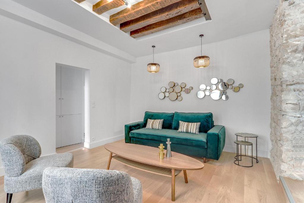 un salon avec un canapé vert et une table dans l'établissement Pick A Flat's Apartment in Le Marais - Rue Saint Apoline, à Paris