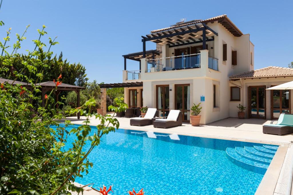a villa with a swimming pool and a house at Aphrodite Hills Rentals - Superior Villas in Kouklia