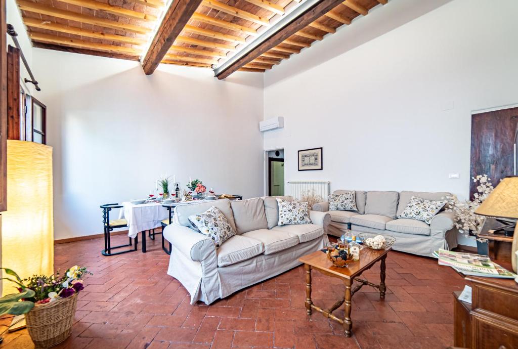Oltrarno Apartment في فلورنسا: غرفة معيشة مع أريكة وطاولة