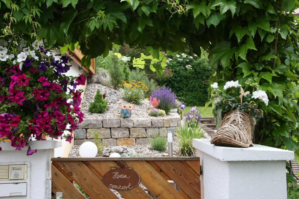 a garden with flowers and a stone wall at Ferienwohnung am Rotdornweg in Heiligenstadt