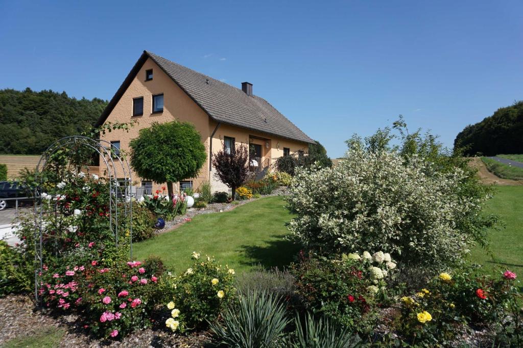 ein Haus mit einem Blumengarten in der Unterkunft Ferienwohnung Penning in Oberfellendorf