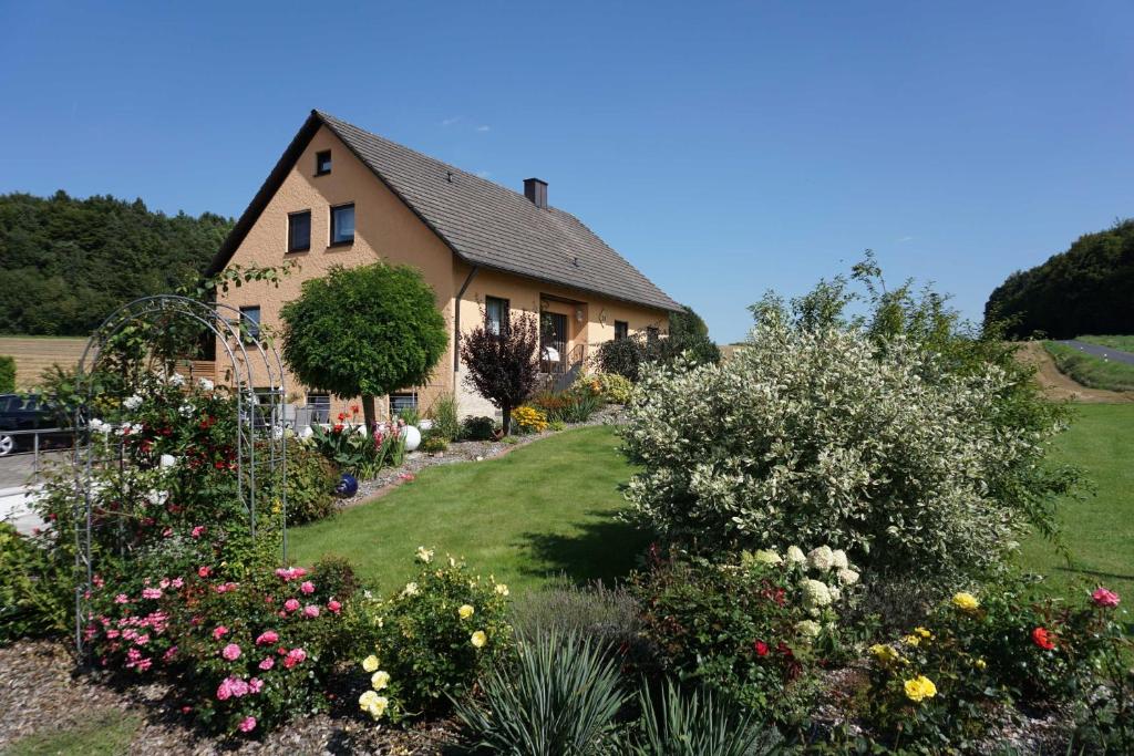 a house with a garden of flowers at Ferienwohnung Penning in Oberfellendorf