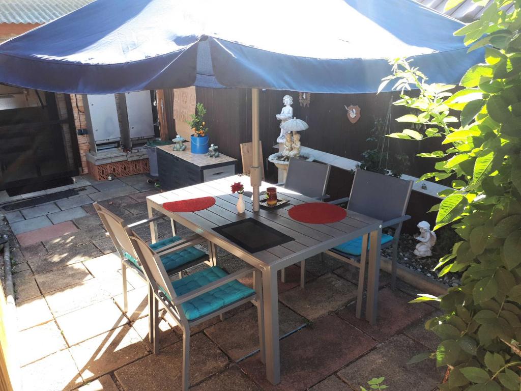 a table and chairs with a blue umbrella at Ferienwohnung Krieger in Thurnau