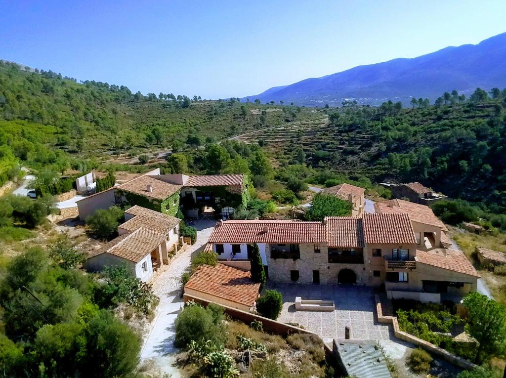 una vista aérea de una casa con montañas en el fondo en Aldea Roqueta Hotel Rural en Els Ibarsos