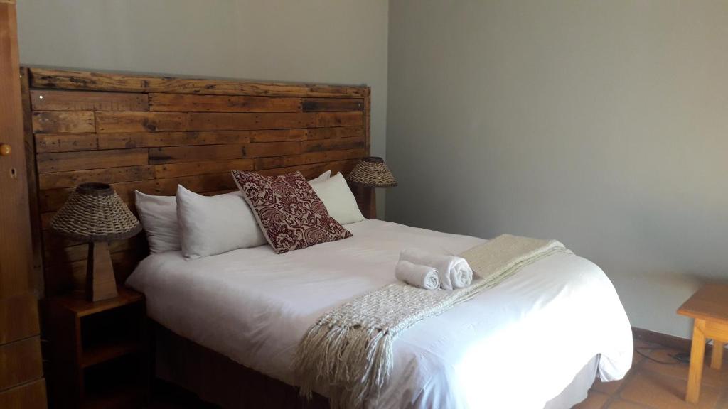a bedroom with a white bed with a wooden headboard at Woodpecker on Marine in Margate