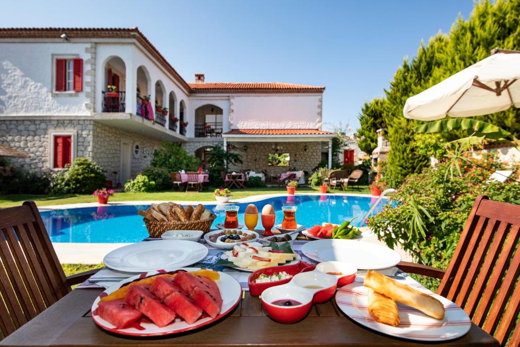 una mesa con platos de comida junto a una piscina en Mercan Köşk, en Alacati